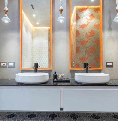 This contemporary bathroom showcases a sleek double sink setup with black countertop, stylish mirrors, and unique lighting fixtures. The design exudes modern elegance and functionality. This contemporary bathroom showcases a sleek double sink setup with black countertop, stylish mirrors, and unique lighting fixtures. The design exudes modern elegance and functionality.