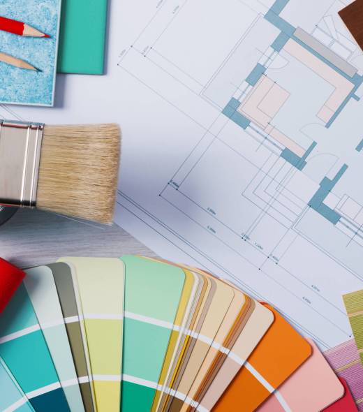 Decorator’s work table with tools Painter and decorator work table with house project, color swatches, painting roller and brush, top view